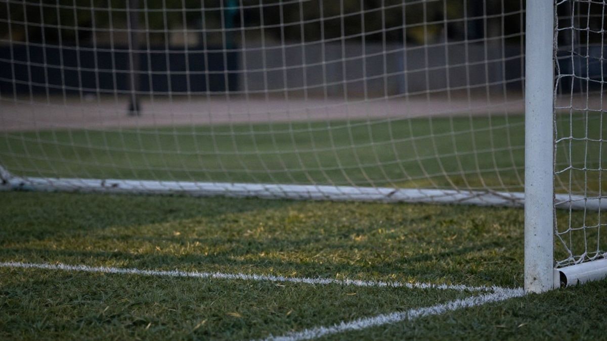 Imagen ilustrativa: red de portería de fútbol al atardecer con el punto de penalti en primer plano