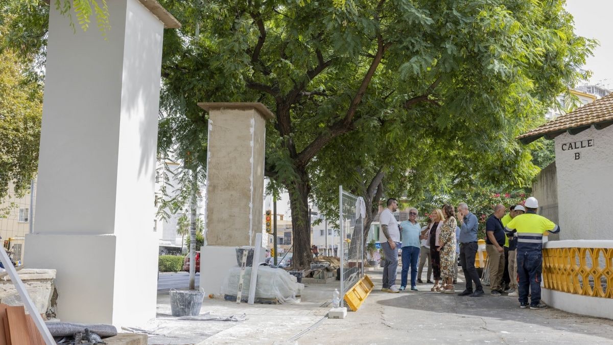 Imagen ilustrativa: rincón de un barrio histórico de ciudad jardín con pilastras de ladrillo y una pequeña zona verde