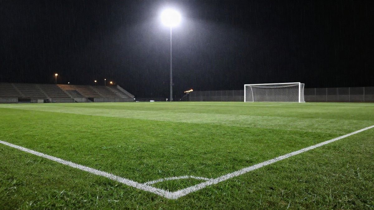 Imagen ilustrativa: estadio de fútbol de noche iluminado por focos, con el césped vacío y una portería al fondo
