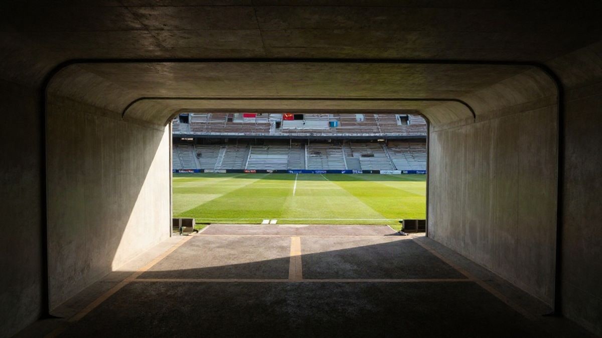 Imagen ilustrativa: túnel de un estadio de fútbol vacío con el césped al fondo