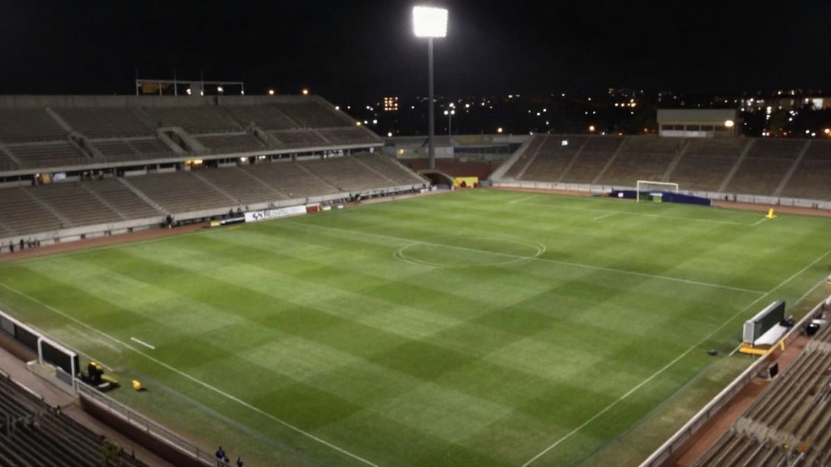 Imagen ilustrativa: vista aérea de un campo de fútbol iluminado por focos nocturnos