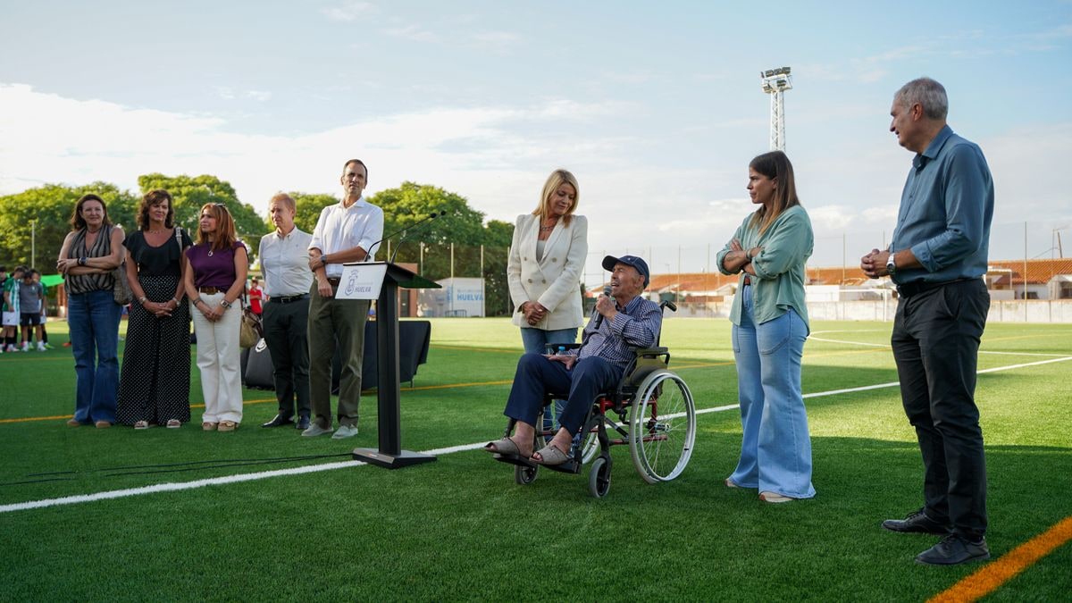 Imagen ilustrativa: campo de fútbol de barrio con césped artificial nuevo y un cono de entrenamiento al atardecer