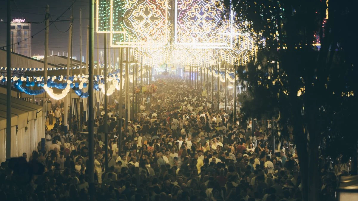 Imagen ilustrativa: vista aérea de un recinto de conciertos al aire libre al atardecer, con escenario y atracciones de feria en un entorno urbano español.