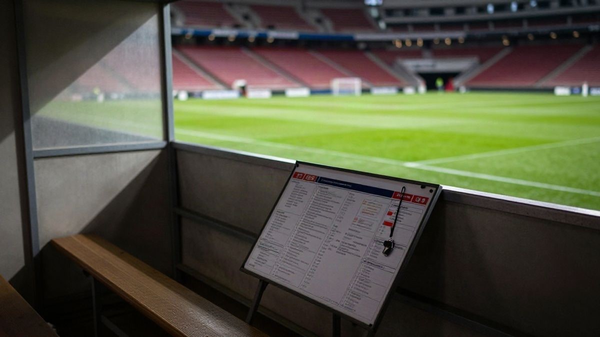 Imagen ilustrativa: banquillo de un estadio de fútbol vacío con una pizarra táctica y un silbato