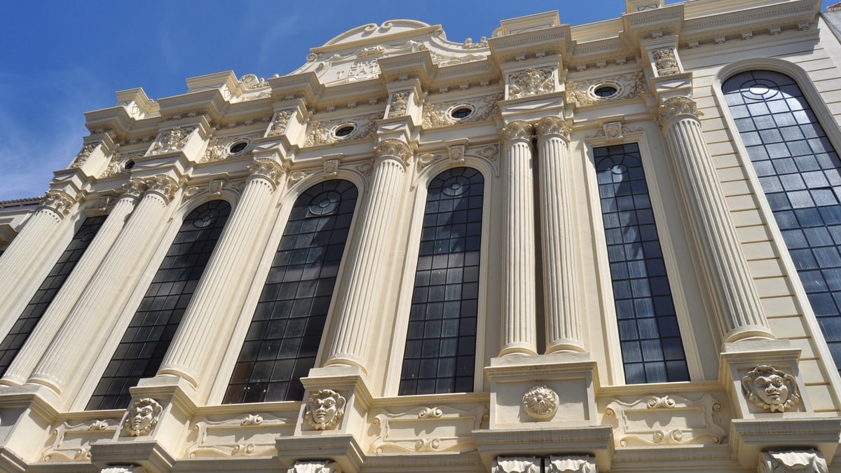 Fachada neoclásica del Gran Teatro de Huelva con columnas, ventanales y relieves ornamentales