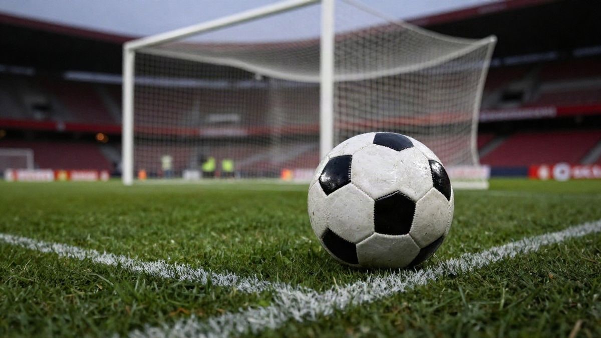 Imagen ilustrativa: un balón de fútbol sobre el punto de penalti de un estadio al atardecer