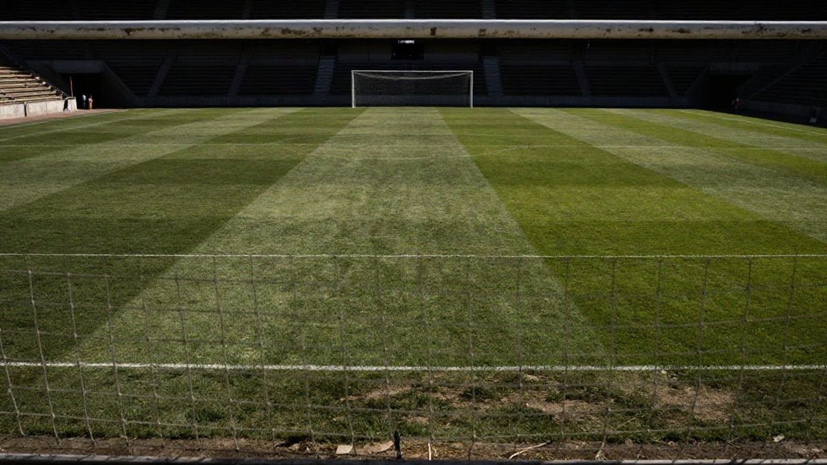 Imagen ilustrativa: campo de fútbol de dimensiones reducidas con la portería al fondo y luz solar intensa