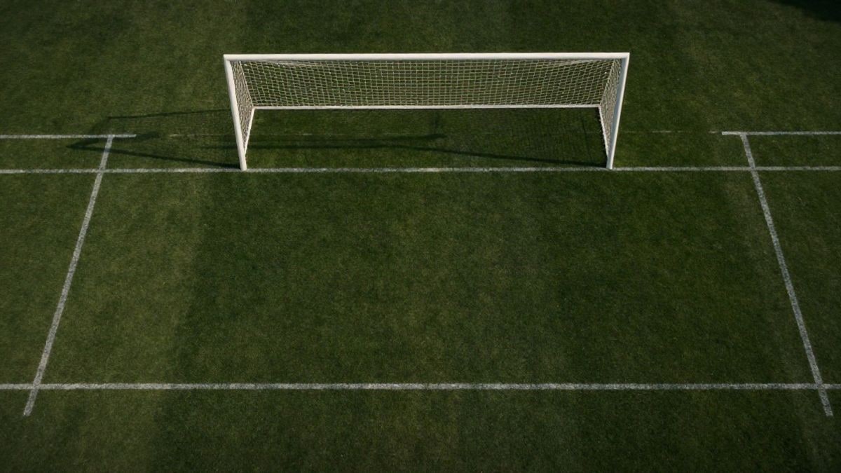 Imagen ilustrativa: vista cenital de un campo de fútbol con líneas blancas y una portería con red