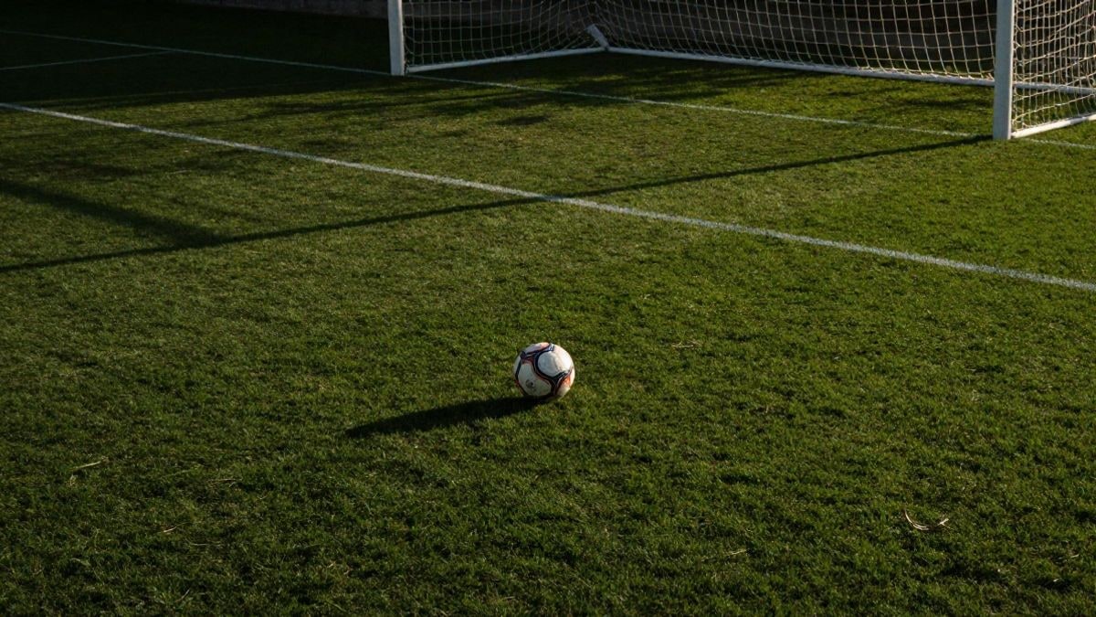 Imagen ilustrativa: vista cenital de un campo de fútbol con un balón en el punto de penalti y la portería al fondo