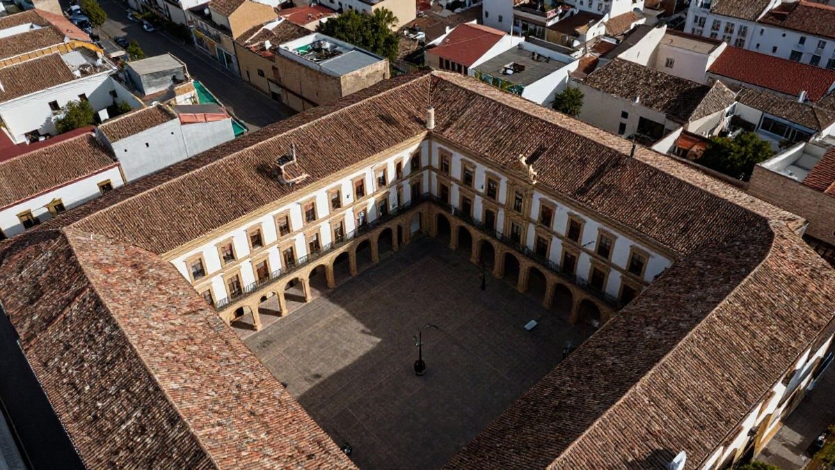 Imagen ilustrativa: vista cenital de un edificio institucional con patio central y tejados rojos