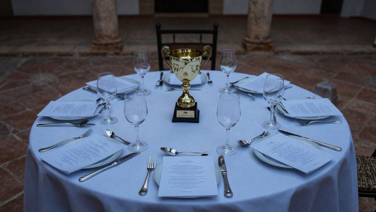Imagen ilustrativa: vista cenital de una mesa de gala con trofeo y programa en un patio andaluz