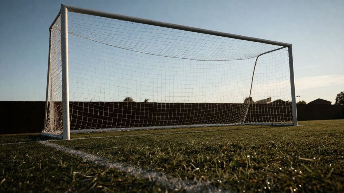 Imagen ilustrativa: portería de fútbol con la red a contraluz y el punto de penalti en primer plano