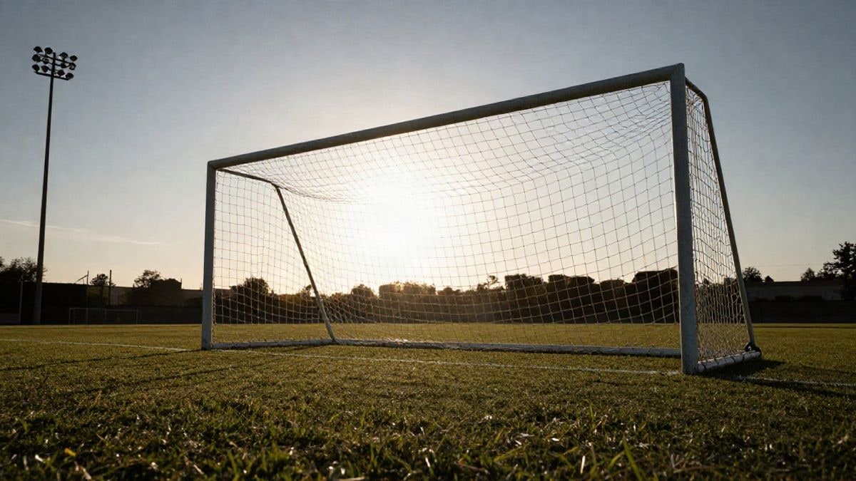 Imagen ilustrativa: una portería de fútbol con la red recortada a contraluz al atardecer, con sombras largas sobre la hierba.