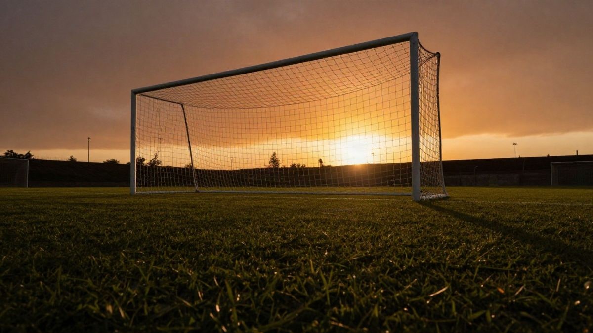 Imagen ilustrativa: portería de fútbol con la red a contraluz en un campo vacío al atardecer