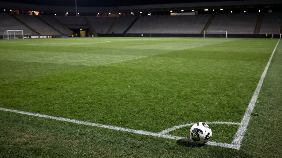 Imagen ilustrativa: vista cenital de un campo de fútbol iluminado con un balón en el césped