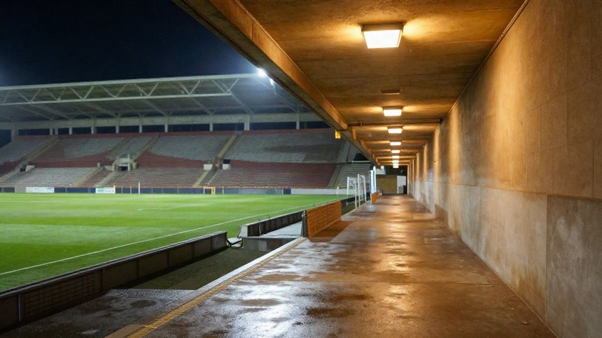 Imagen ilustrativa: pasillo de un estadio de fútbol de noche, iluminado por focos y sin personas