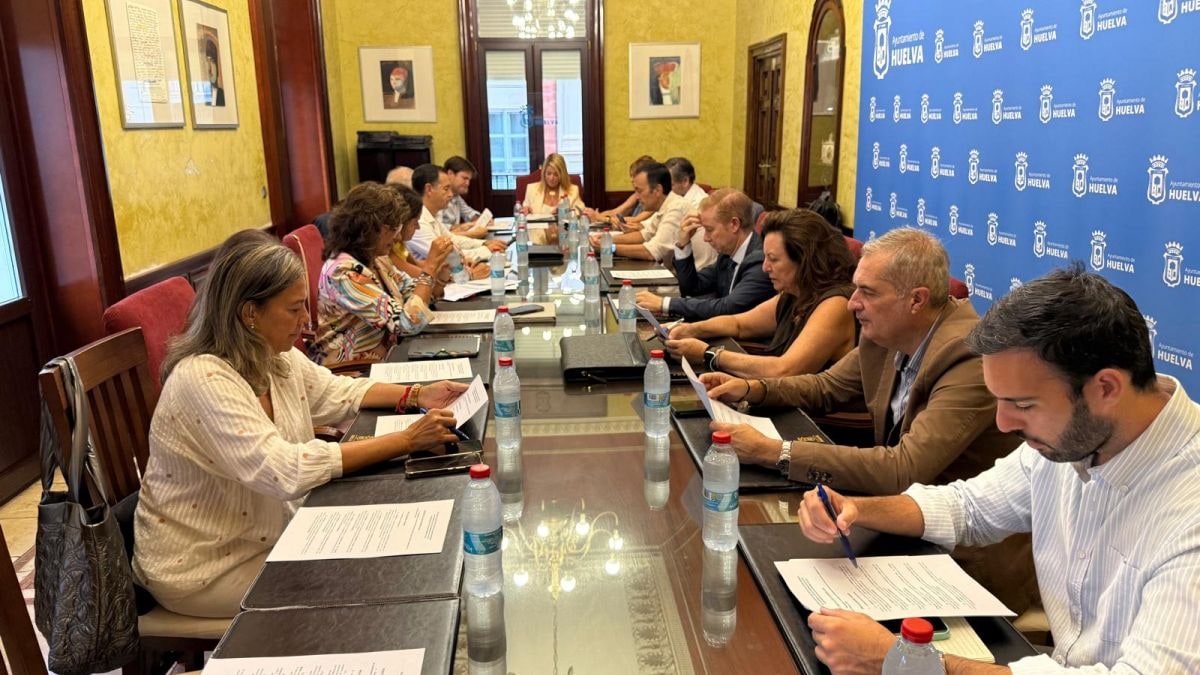Imagen ilustrativa: vista cenital de un equipo de atención domiciliaria sobre una mesa de madera con cuaderno y tensiómetro
