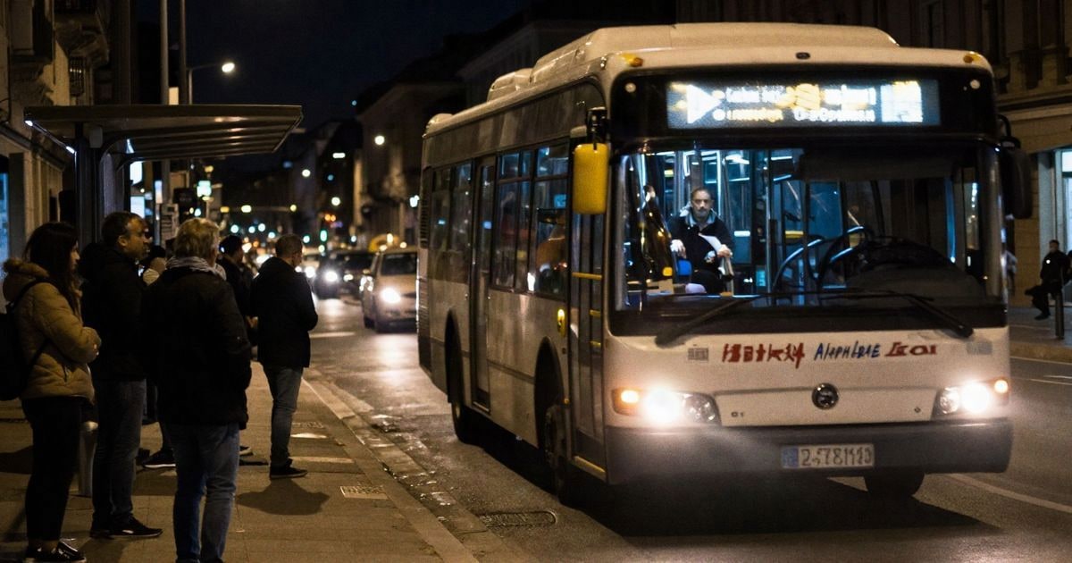 Imagen ilustrativa: un autobús urbano nocturno con las luces encendidas en una calle de la ciudad.
